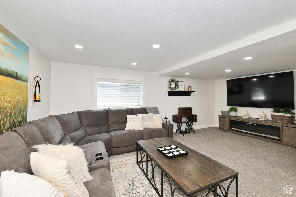 Living room with light colored carpet, recessed lighting, and baseboards