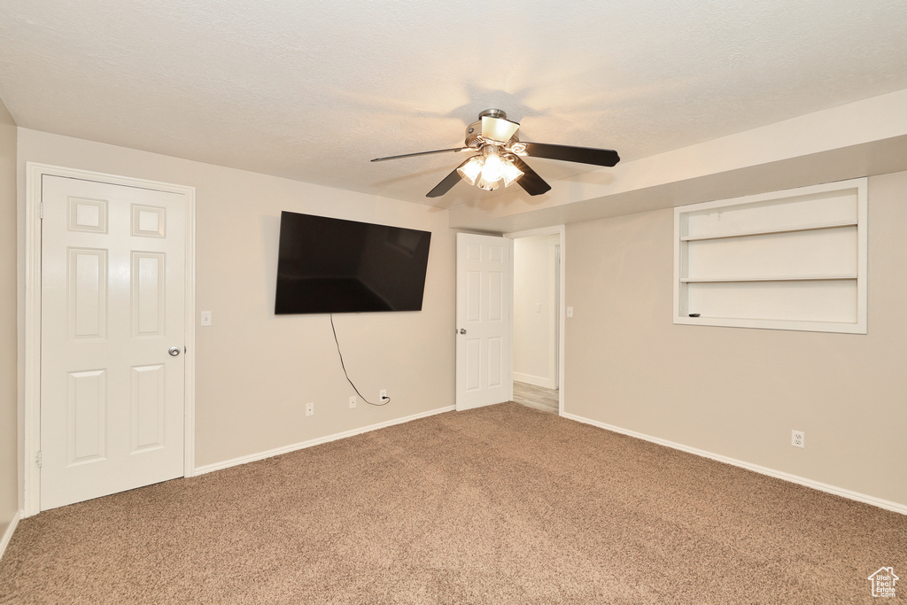 Unfurnished bedroom featuring carpet flooring, baseboards, and a ceiling fan