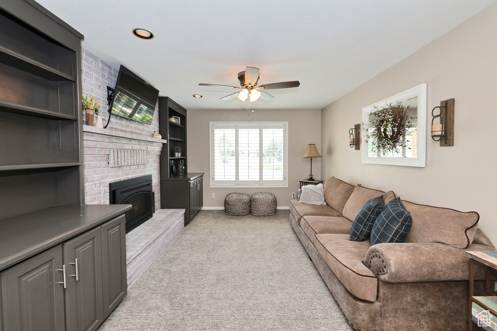 Living area with ceiling fan, a fireplace, light carpet, baseboards, and recessed lighting