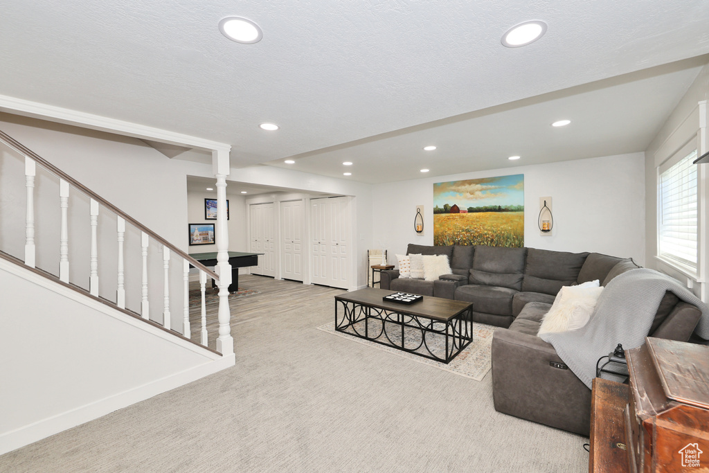 Living room featuring recessed lighting, carpet flooring, and stairway