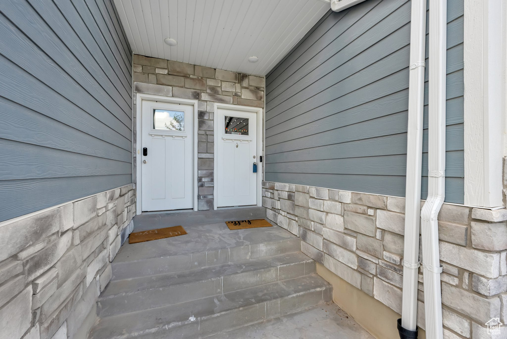 Entrance to property featuring stone siding