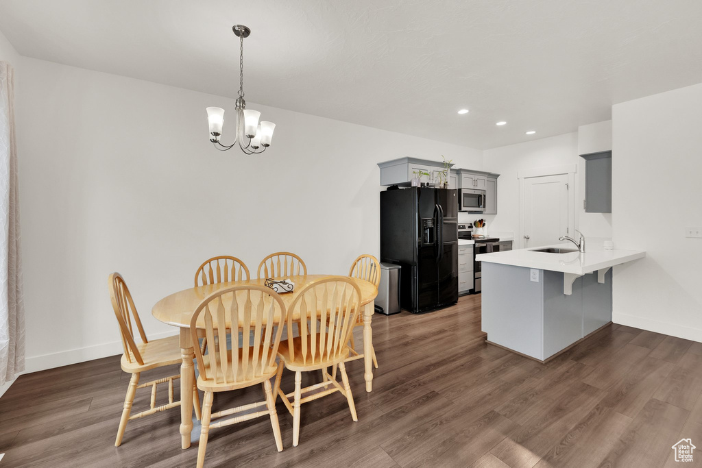 Dining room featuring a chandelier, recessed lighting, dark wood-style floors, and baseboards