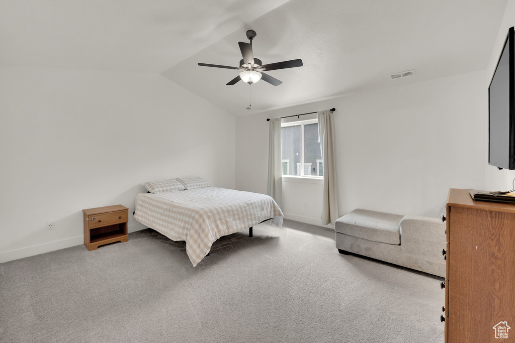 Bedroom featuring baseboards, vaulted ceiling, carpet floors, and a ceiling fan