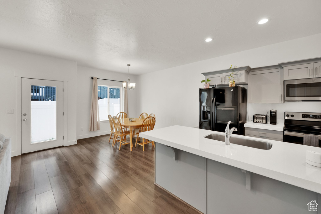 Kitchen featuring appliances with stainless steel finishes, gray cabinetry, a sink, light countertops, and recessed lighting