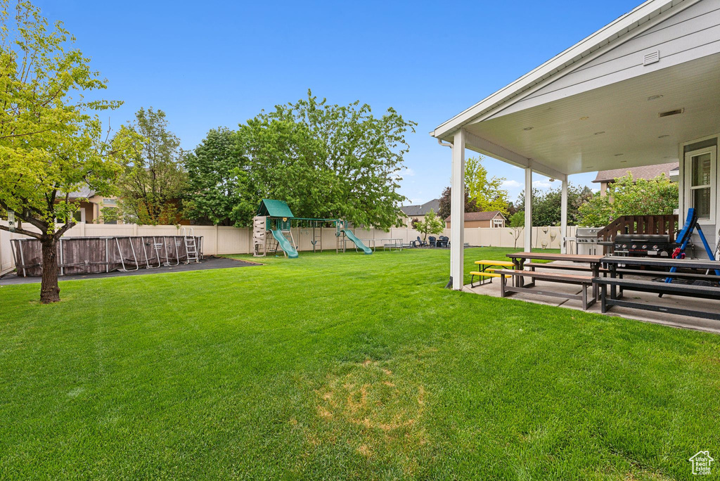 View of yard with a playground and a patio