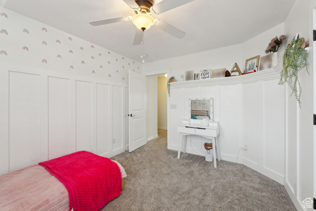 Carpeted bedroom with a ceiling fan