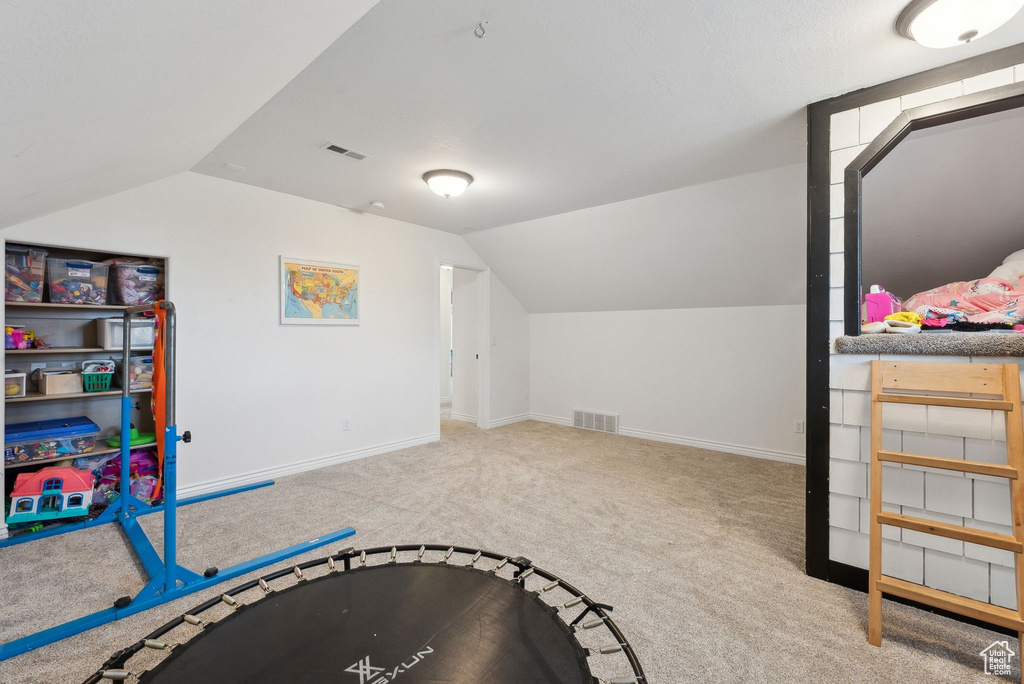 Rec room featuring carpet floors, vaulted ceiling, and baseboards