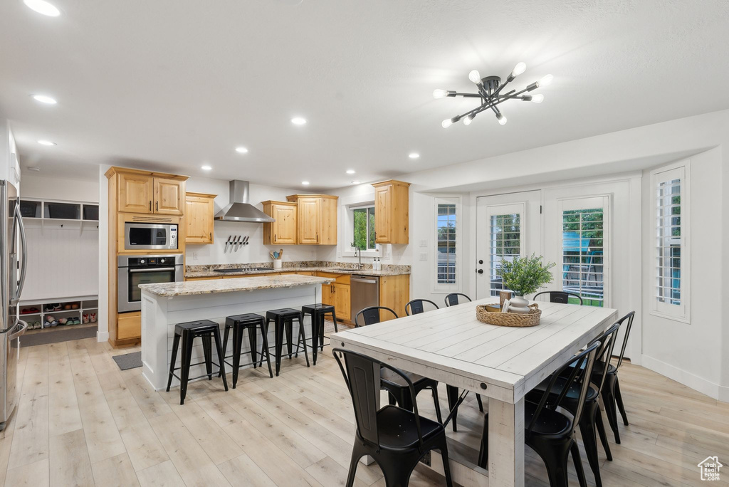 Dining room with light wood-type flooring, recessed lighting, a chandelier, and baseboards