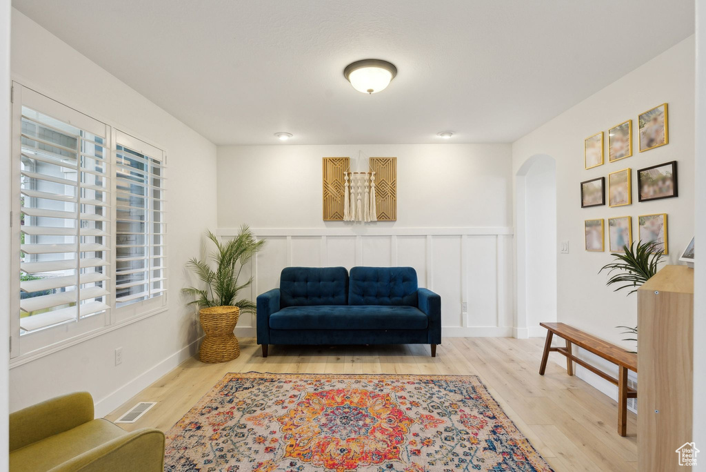 Living area featuring arched walkways and wood finished floors