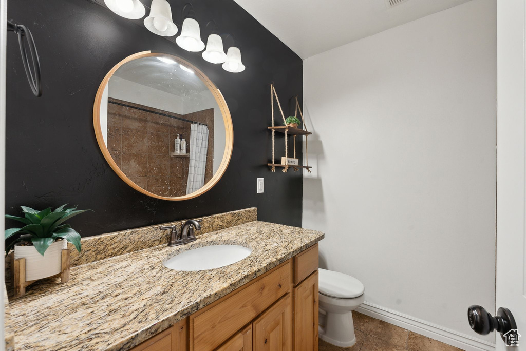 Bathroom with toilet, vanity, tile patterned flooring, a shower with shower curtain, and baseboards