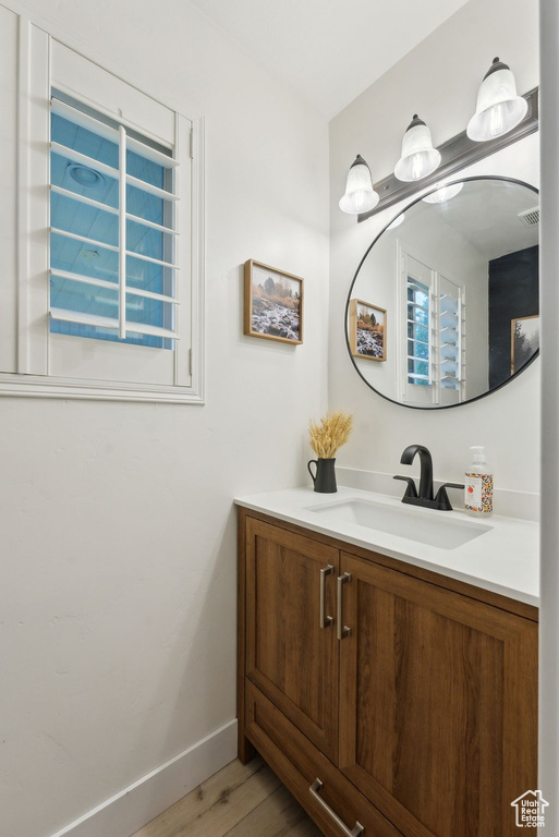 Bathroom with wood finished floors, vanity, and baseboards