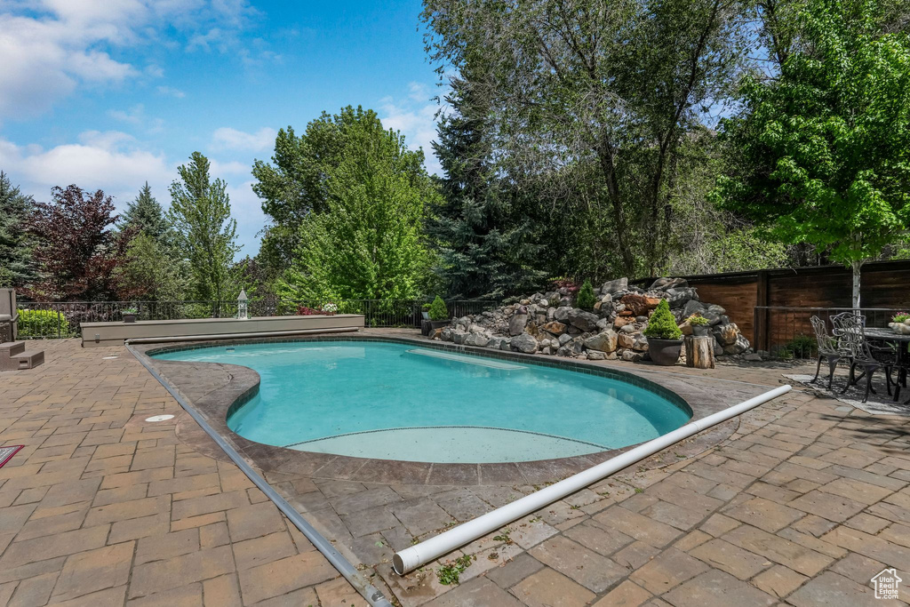 Swimming pool featuring a patio and fence