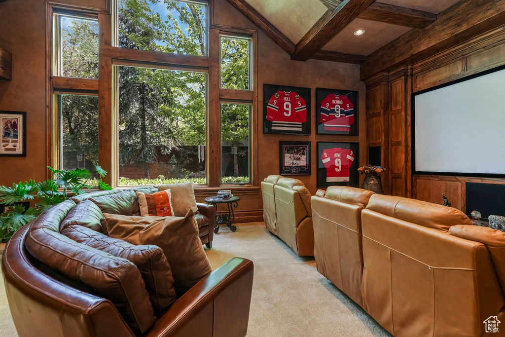Cinema room with plenty of natural light, beamed ceiling, and light colored carpet