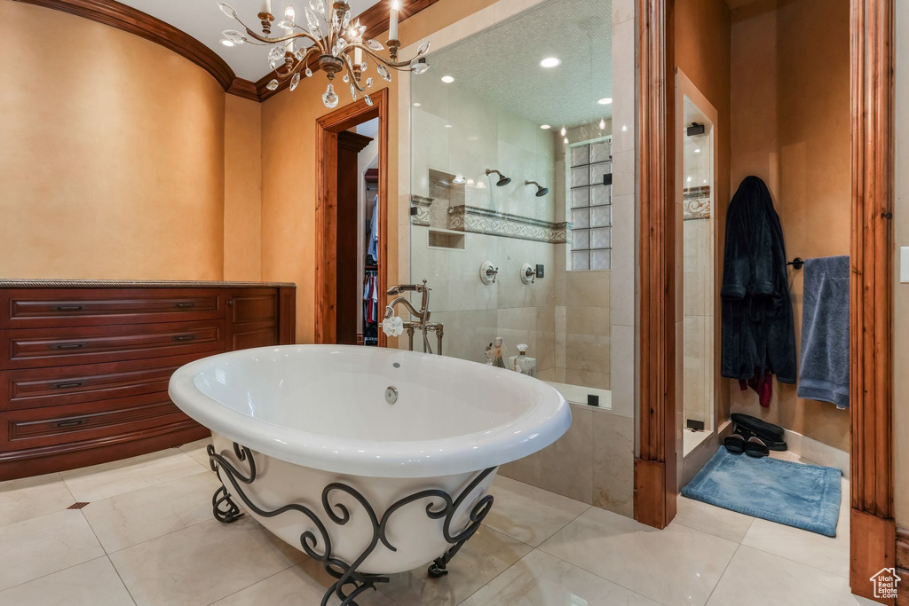 Bathroom featuring a freestanding bath, a chandelier, tiled shower, and tile patterned flooring
