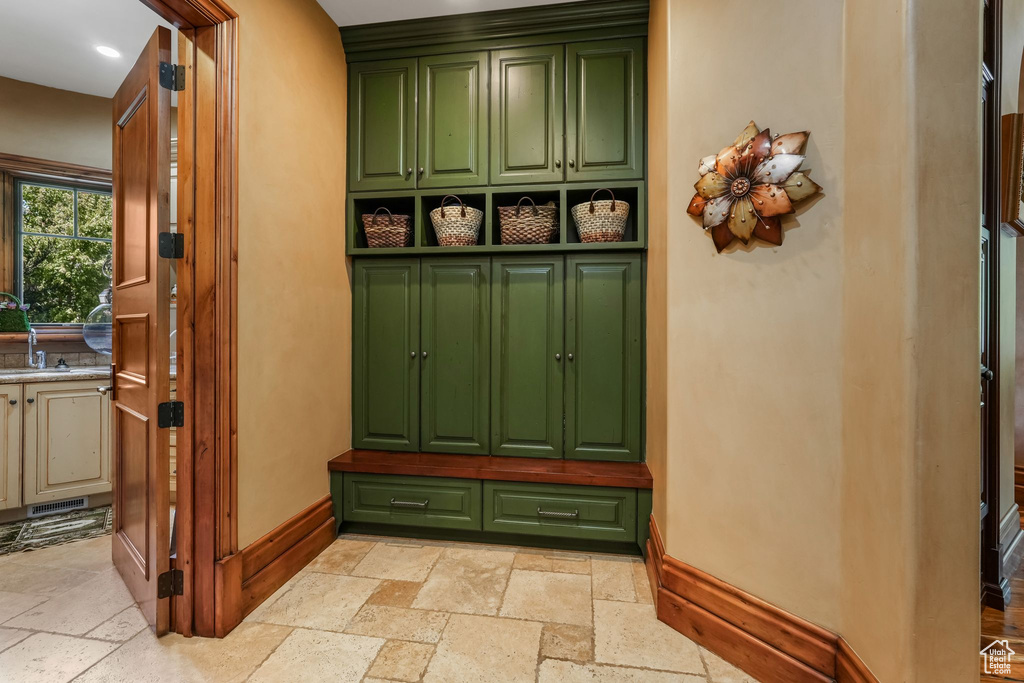 Mudroom with stone tile floors, baseboards, a sink, and recessed lighting