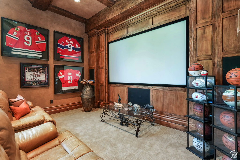 Cinema room featuring carpet, beamed ceiling, and wood walls