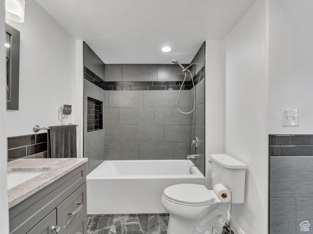 Full bathroom with toilet, shower / bath combination, and vanity
