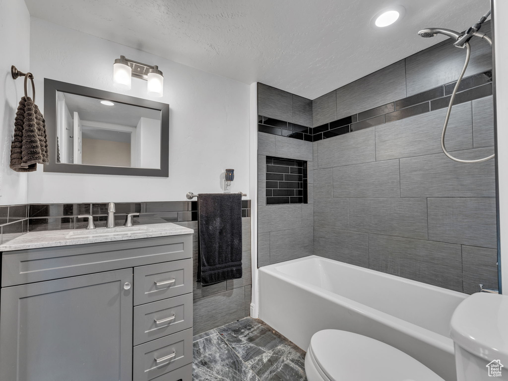 Bathroom featuring toilet, vanity, washtub / shower combination, recessed lighting, and a textured ceiling