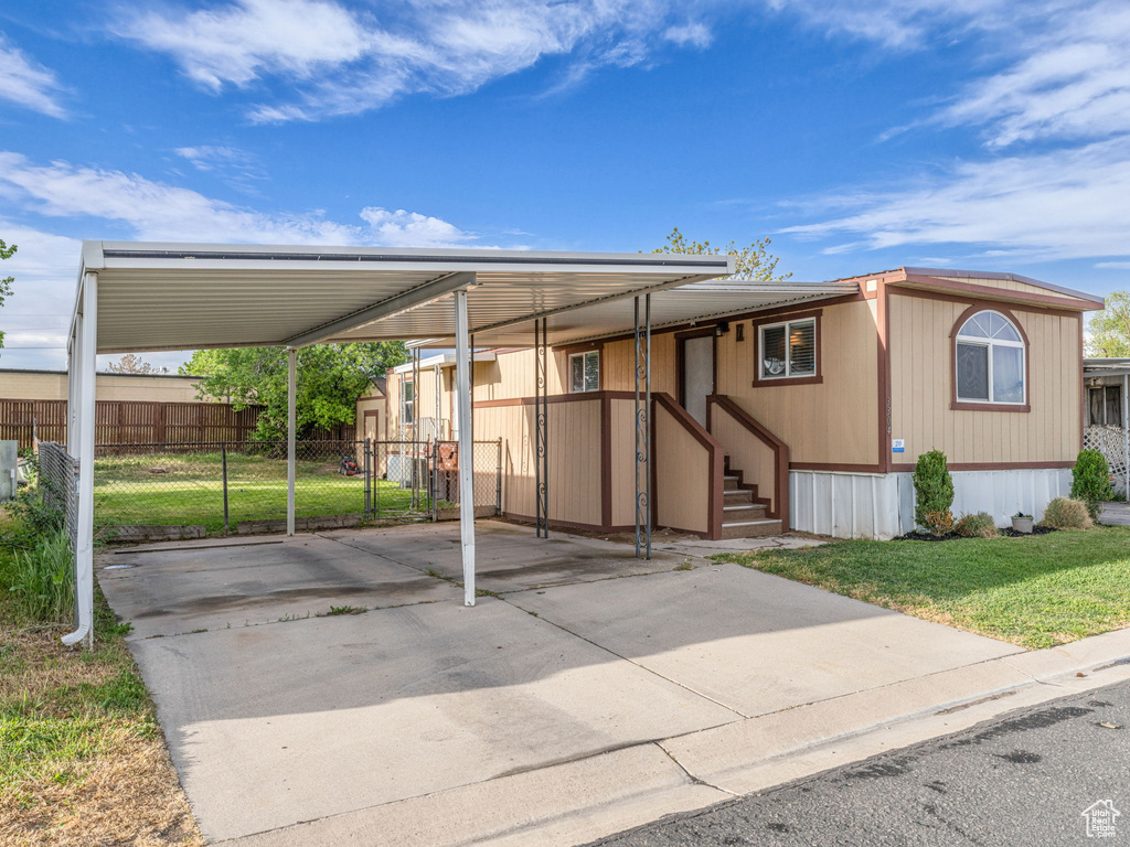 View of front of home with driveway and a carport