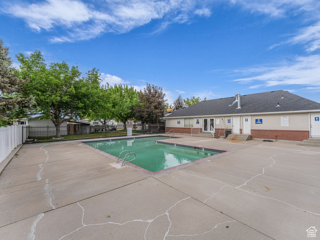 Community pool featuring entry steps, a patio, and fence
