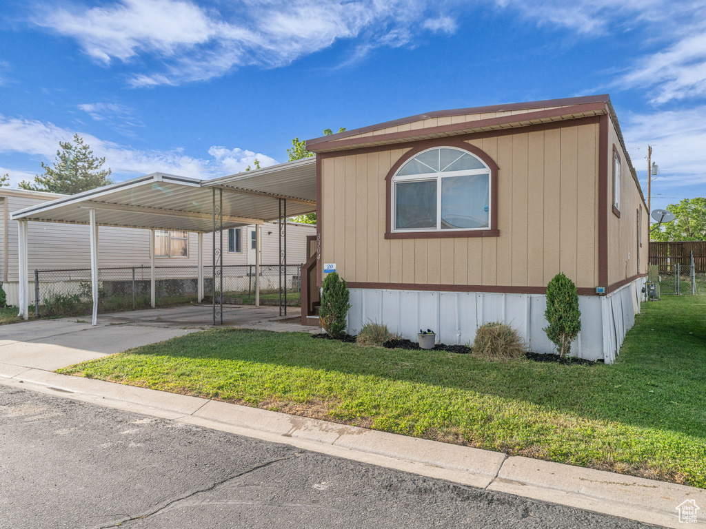 Manufactured / mobile home featuring a carport and concrete driveway