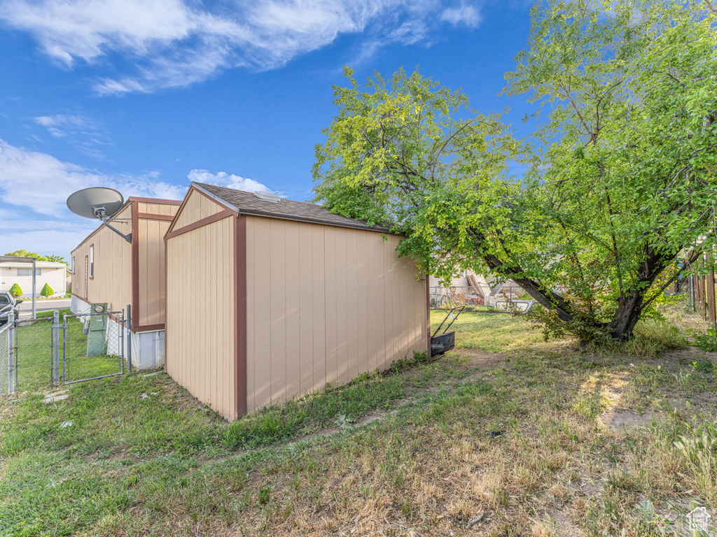 View of yard with a gate, a storage unit, and an outdoor structure