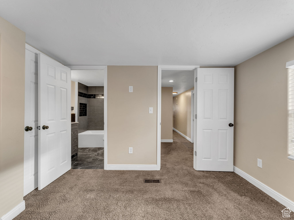 Unfurnished bedroom with carpet, baseboards, and ensuite bath