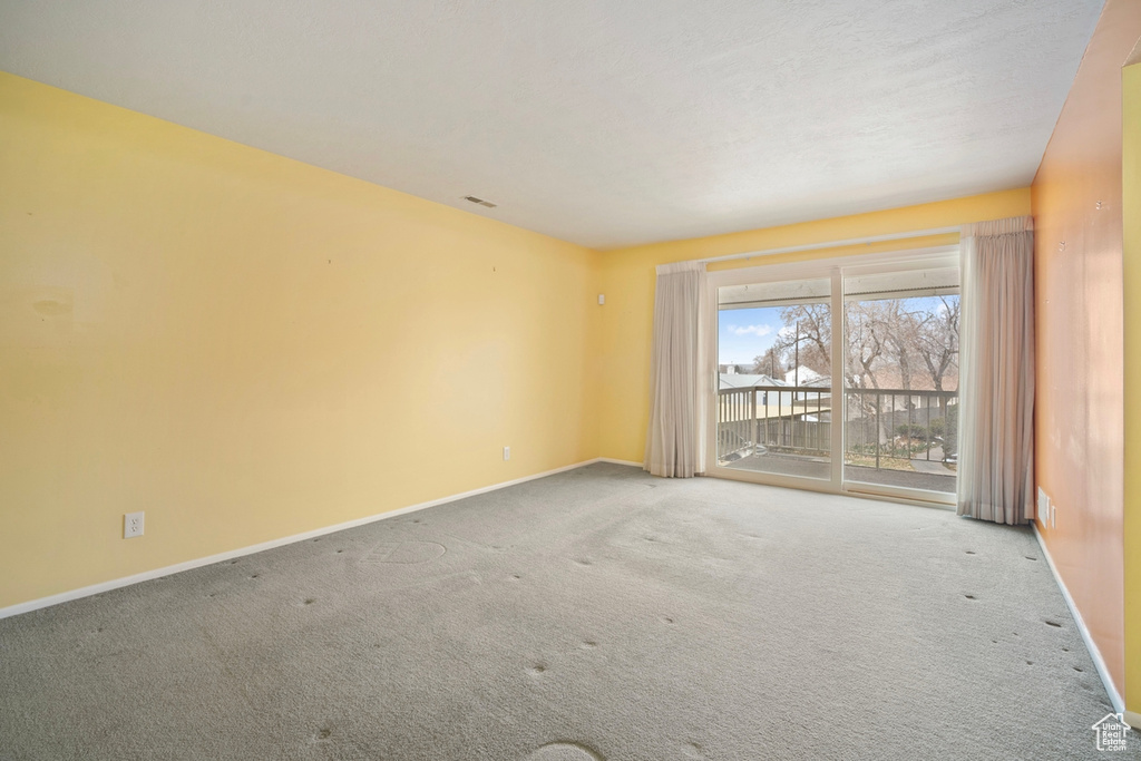 Spare room featuring baseboards and carpet floors