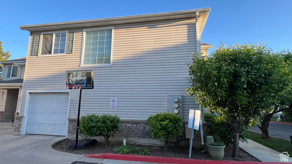 View of side of property featuring an attached garage and driveway