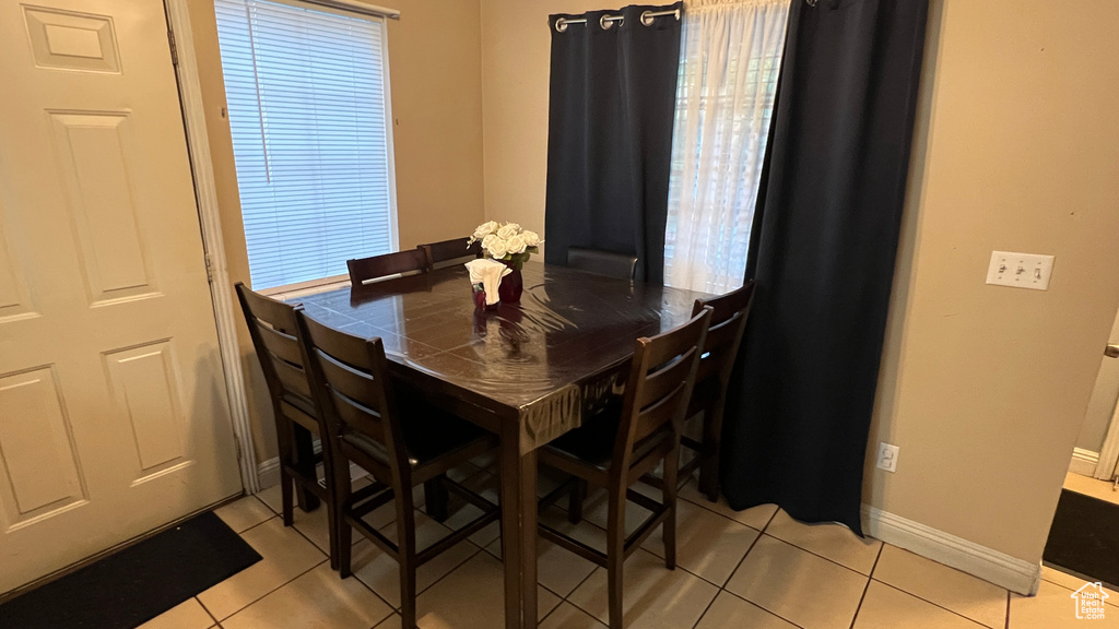 Dining space with light tile patterned floors and baseboards