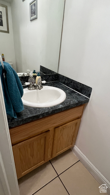 Bathroom featuring vanity, tile patterned floors, and baseboards