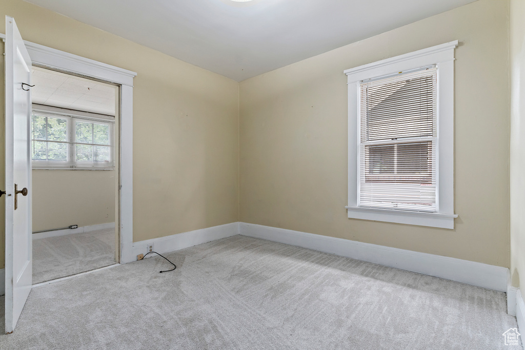 Carpeted empty room with baseboards