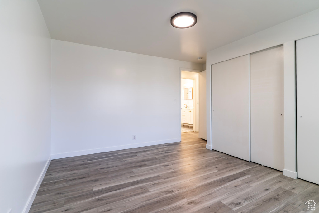 Unfurnished bedroom featuring light wood-type flooring and baseboards
