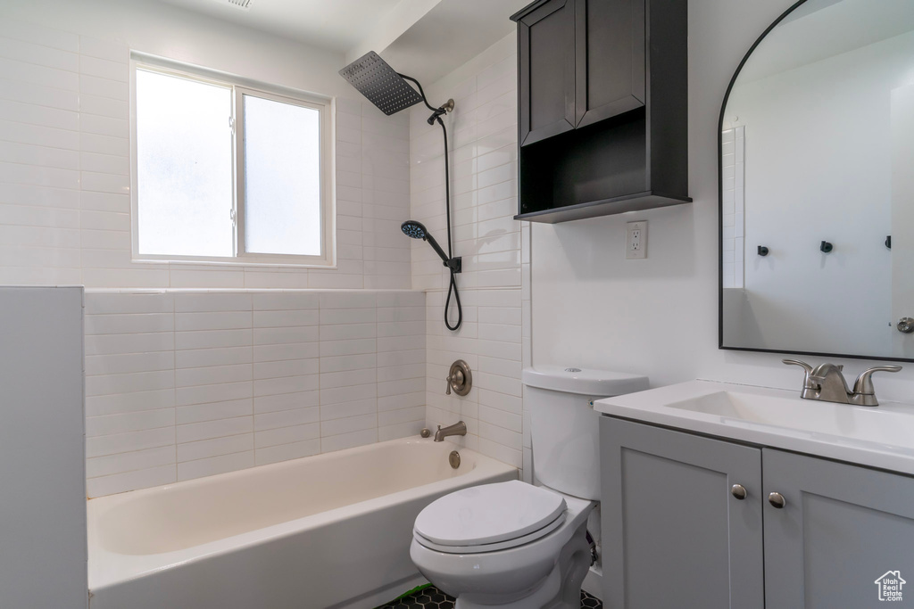 Bathroom with toilet, shower / washtub combination, and vanity