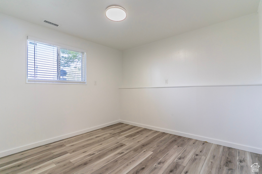 Empty room with light wood-style flooring and baseboards