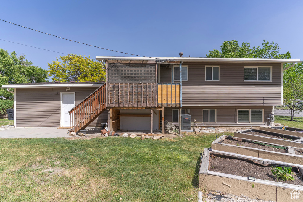 Back of property with a garden, stairway, a deck, and central AC