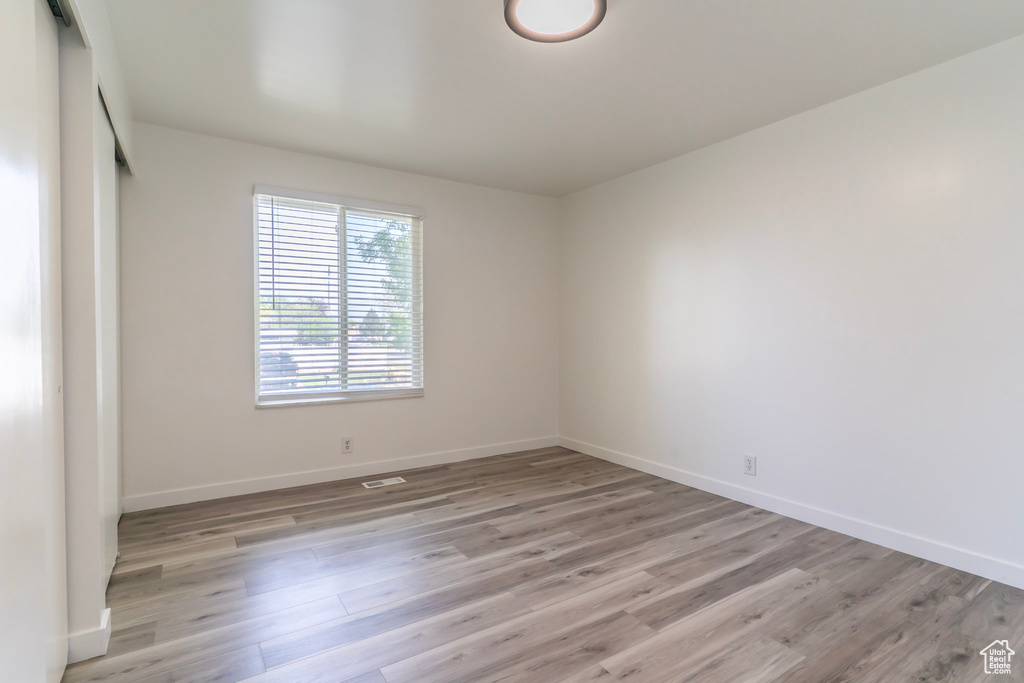 Empty room with light wood-style floors and baseboards