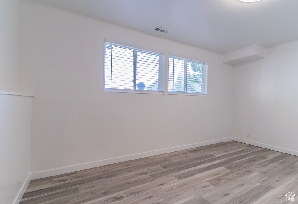 Unfurnished room featuring light wood finished floors and baseboards