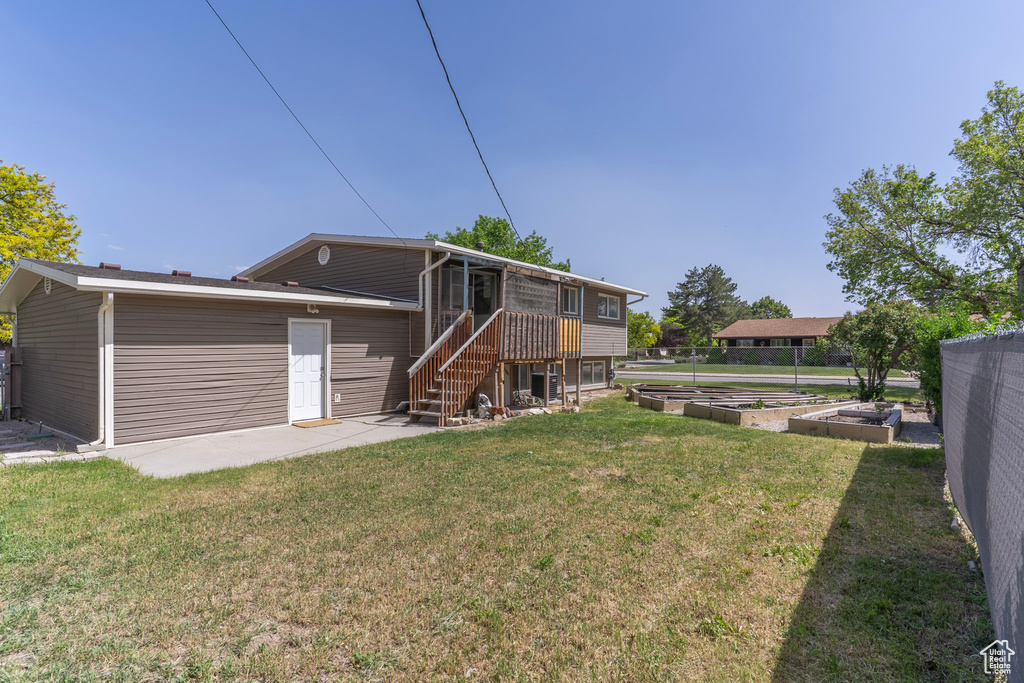 Rear view of house featuring a garden and stairway