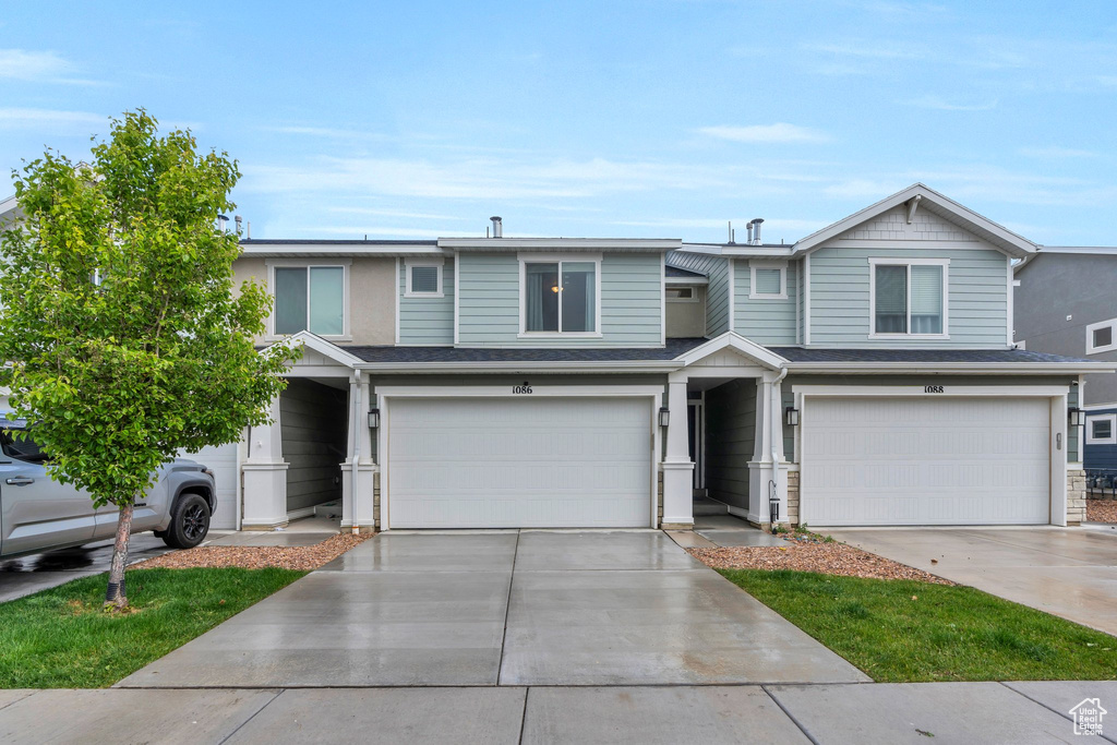 View of front of home with an attached garage and concrete driveway
