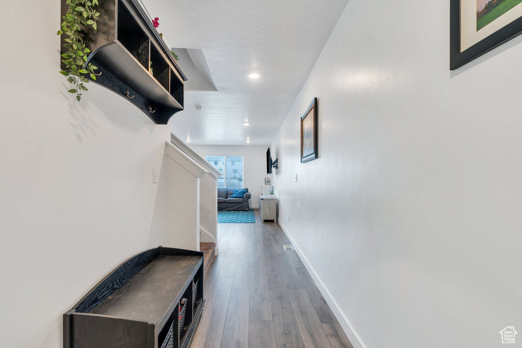 Hallway featuring wood finished floors, baseboards, and recessed lighting