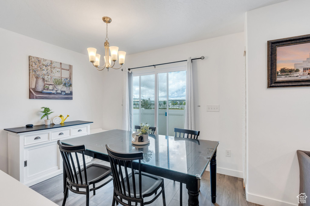 Dining space with a chandelier, dark wood-type flooring, and baseboards