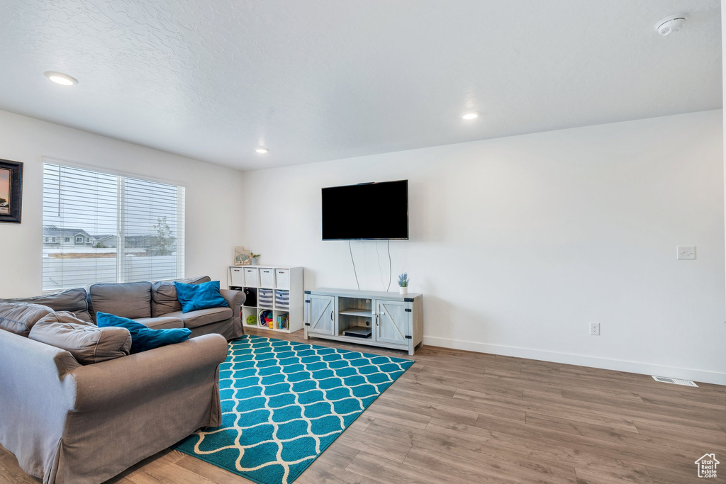 Living area featuring wood finished floors, recessed lighting, and baseboards