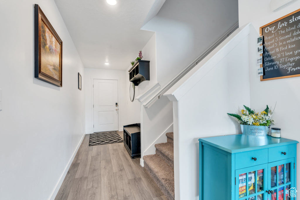 Entryway with wood finished floors, stairway, baseboards, and recessed lighting