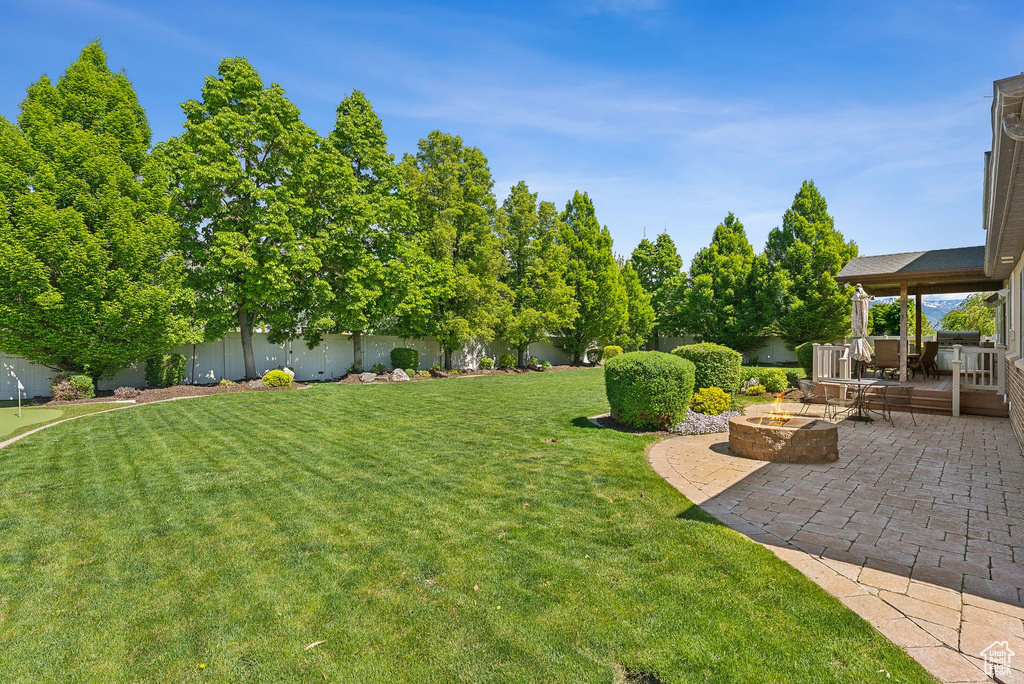 View of yard featuring a fire pit, a patio, and a wooden deck