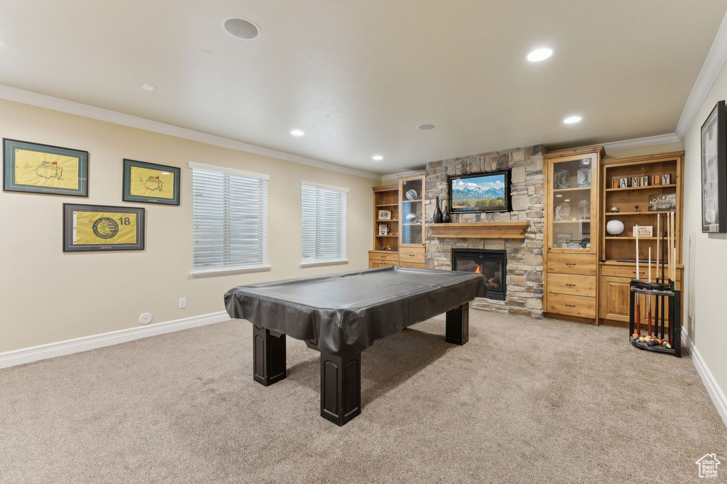 Recreation room with light colored carpet, a stone fireplace, ornamental molding, recessed lighting, and billiards table