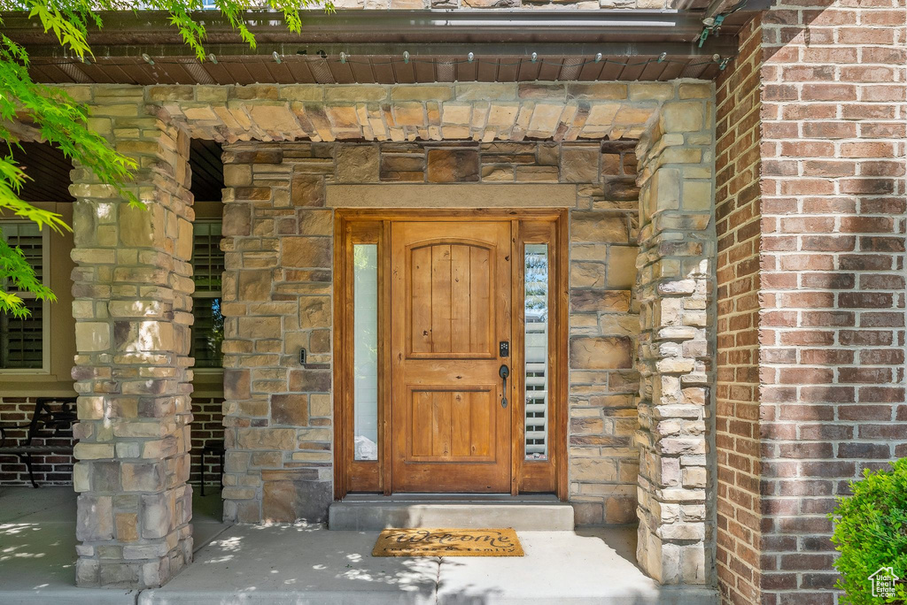 Entrance to property with brick siding and stone siding