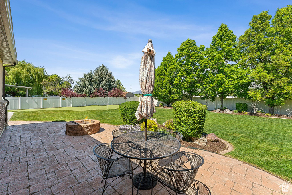 View of patio with a fire pit and outdoor dining area