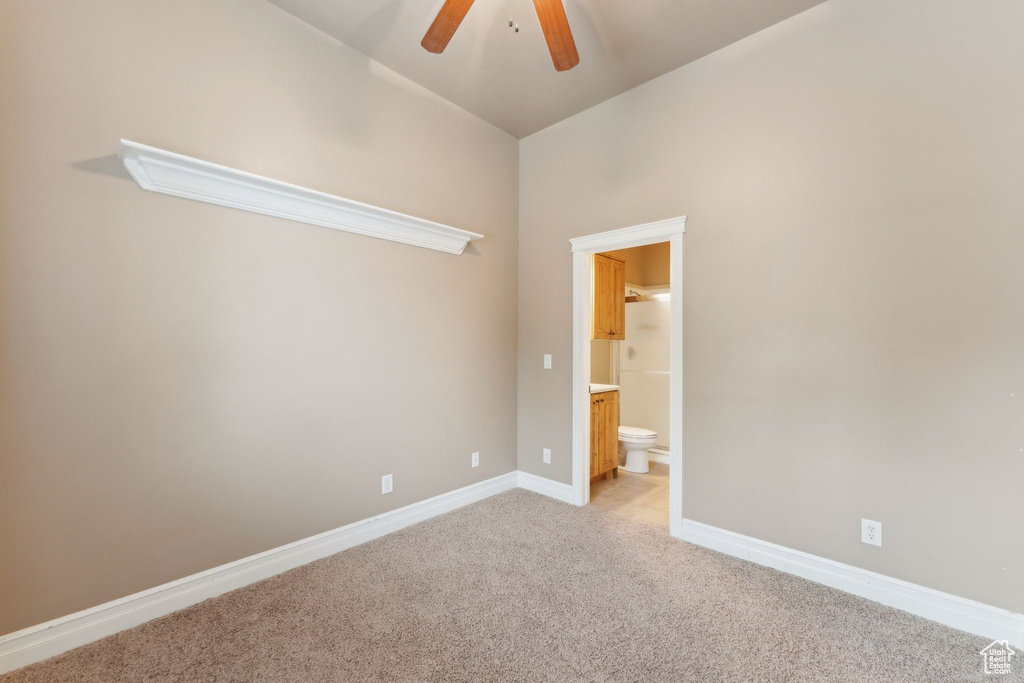 Empty room featuring ceiling fan, light colored carpet, and baseboards
