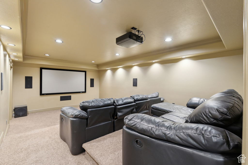 Carpeted home theater room featuring a tray ceiling, crown molding, recessed lighting, and baseboards